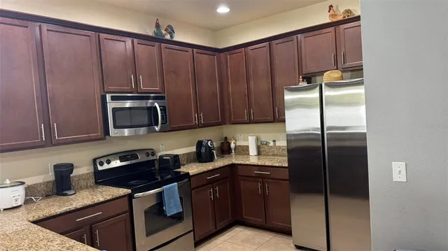 a kitchen with stainless steel appliances granite countertop a refrigerator a stove a sink and dishwasher