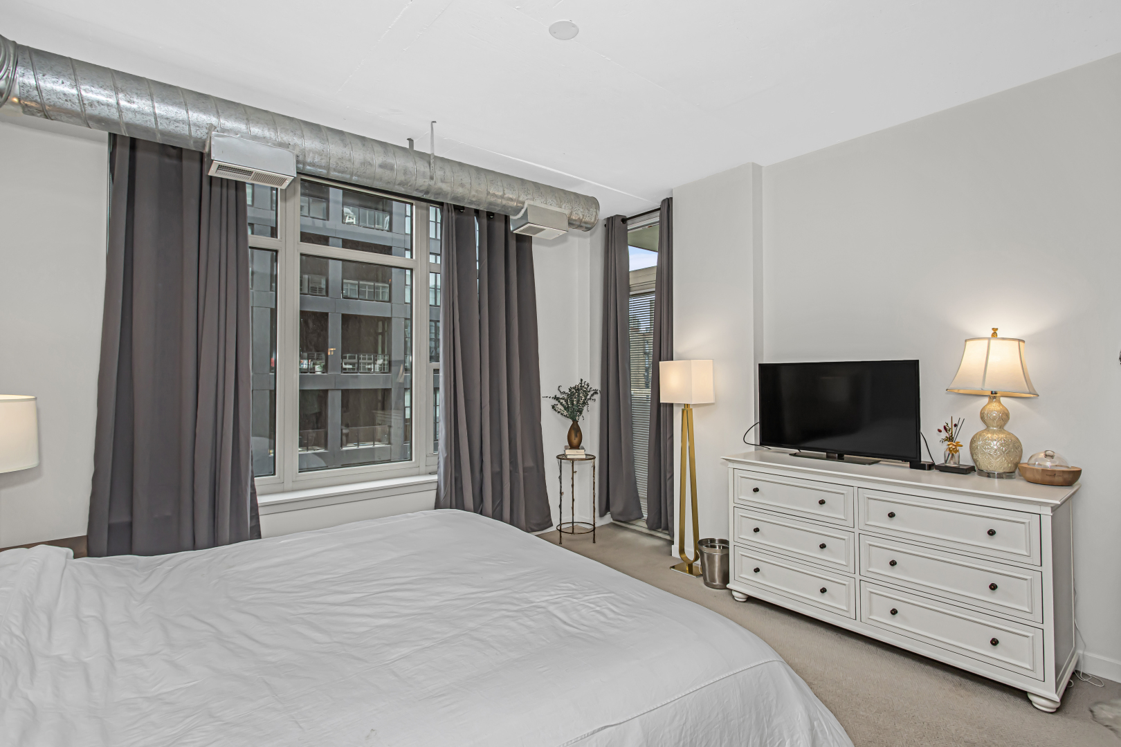 909 West Washington Boulevard, Unit 513 Chicago, IL 60607 - Photo 14 of 25 a bedroom with a bed and a flat screen tv