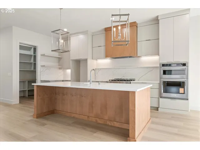 a kitchen with kitchen island granite countertop cabinets and stainless steel appliances