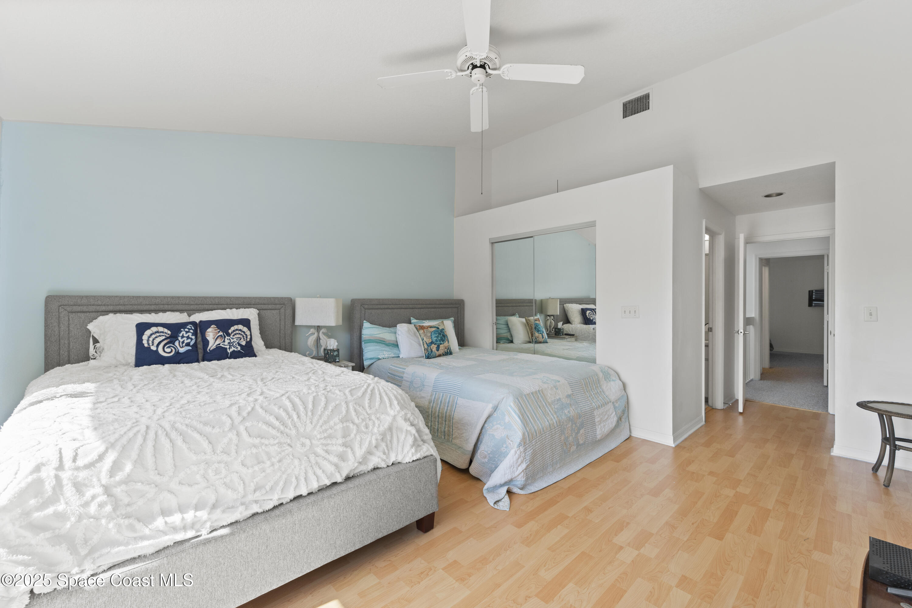 135 Escambia Lane, Unit 204 Cocoa Beach, FL 32931 - Photo 16 of 23 a bedroom with a bed and a mirror