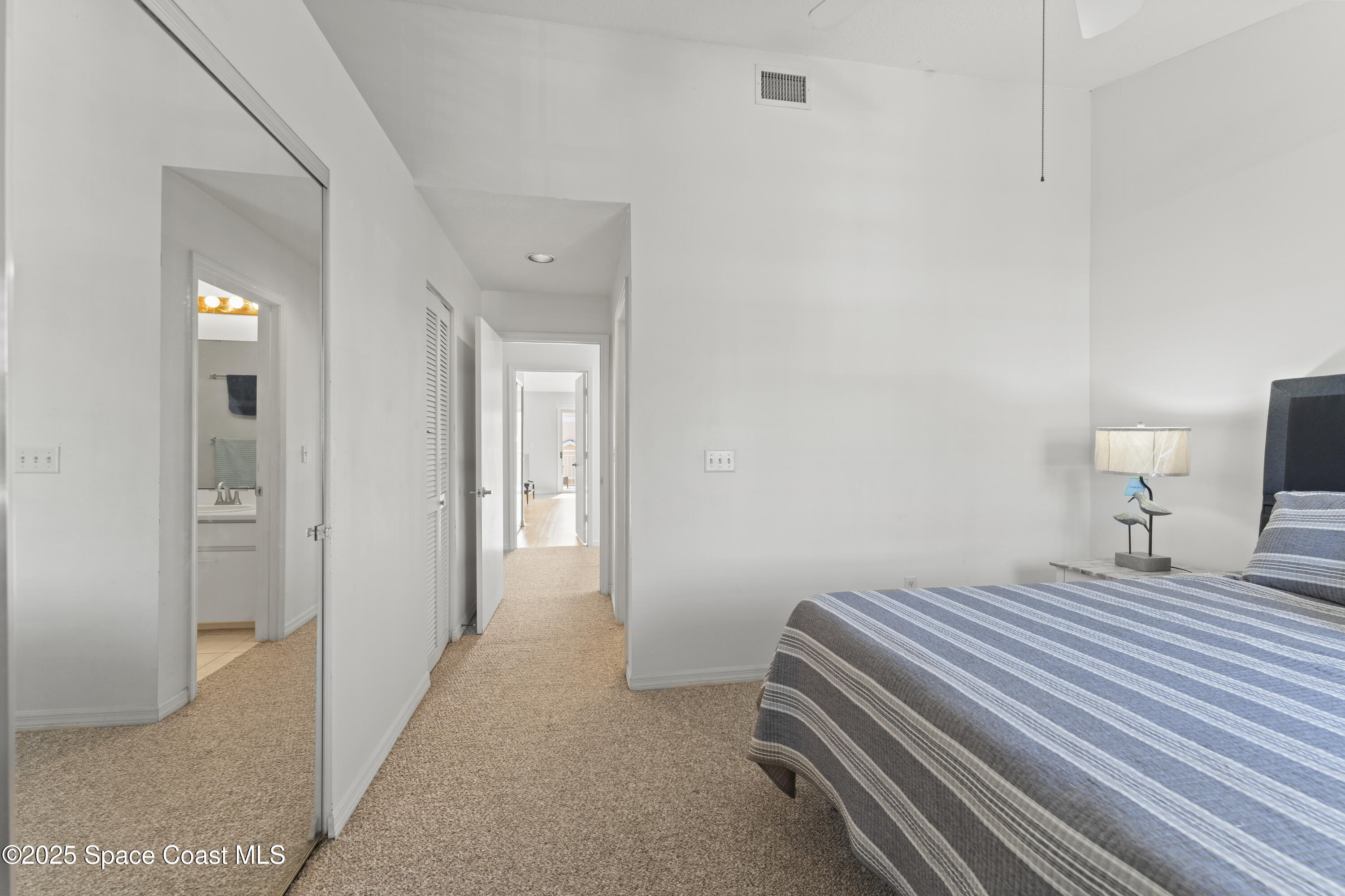 135 Escambia Lane, Unit 204 Cocoa Beach, FL 32931 - Photo 22 of 23 a bedroom with a bed and a lamp