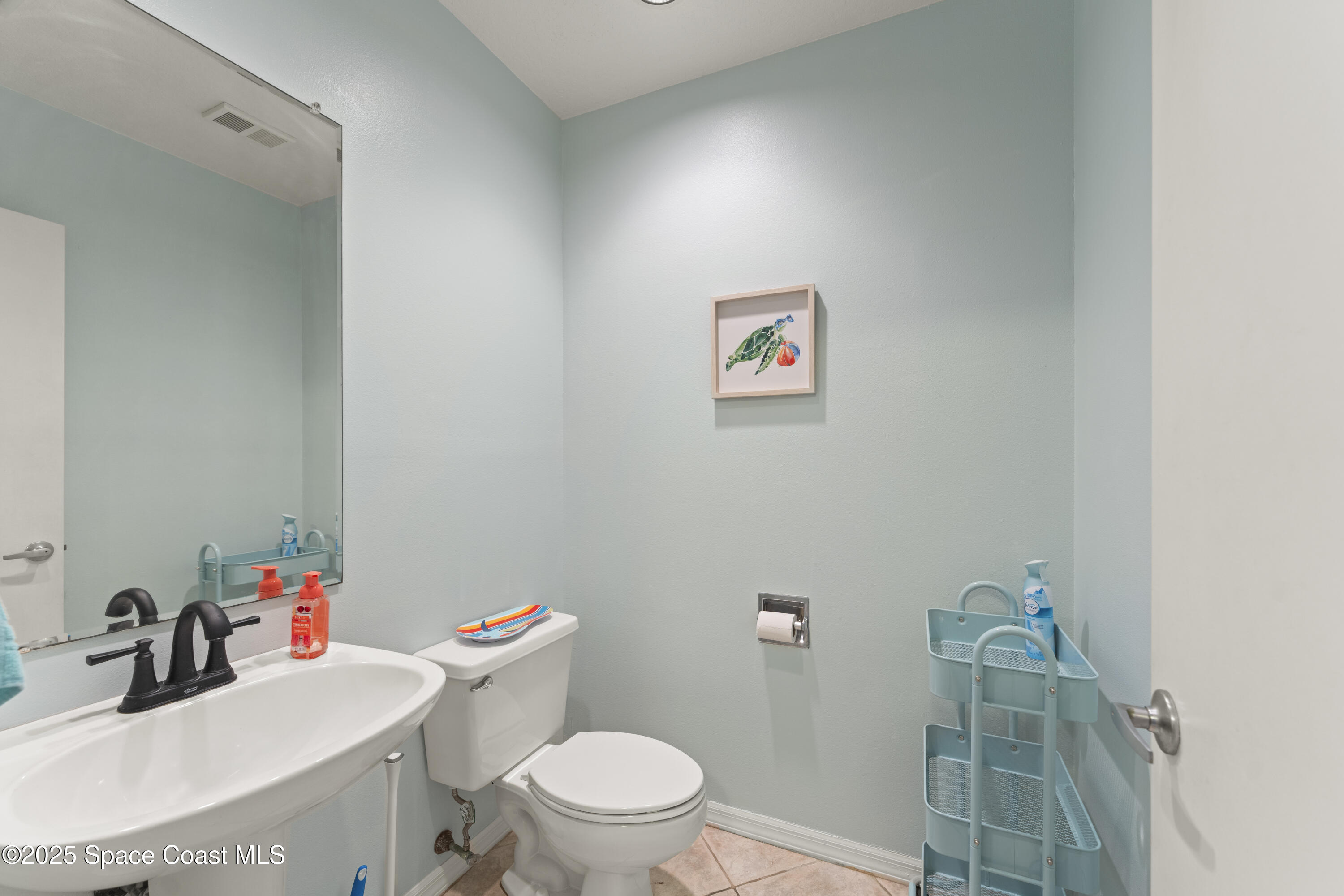 135 Escambia Lane, Unit 204 Cocoa Beach, FL 32931 - Photo 5 of 23 a bathroom with a sink mirror vanity and toilet