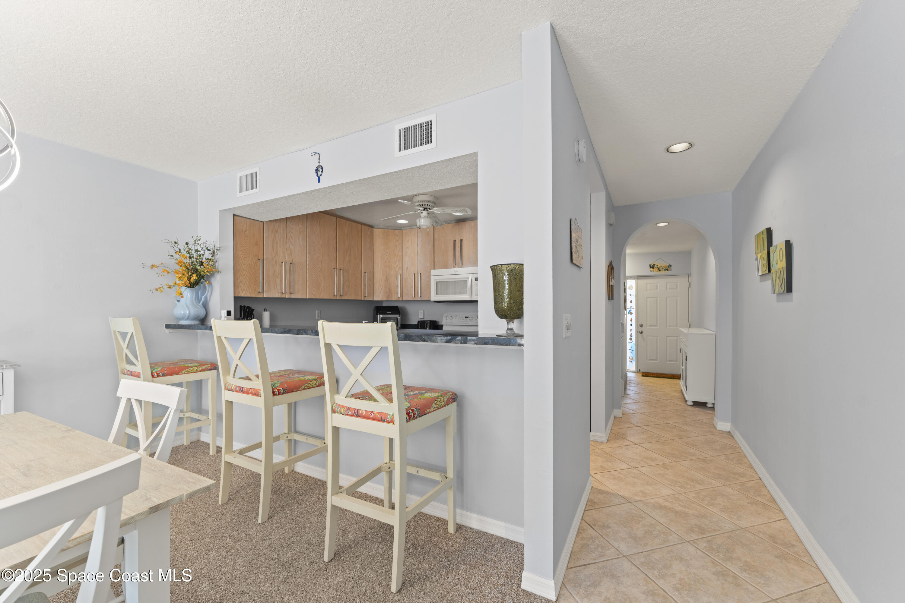 135 Escambia Lane, Unit 204 Cocoa Beach, FL 32931 - Photo 8 of 23 a dining room with furniture and a kitchen