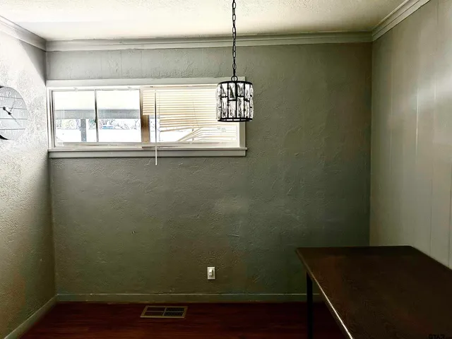 a view of a small space with wooden floor and a window