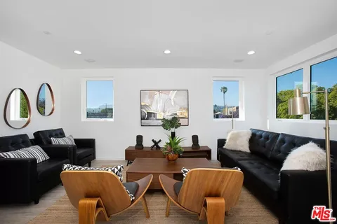 a living room with furniture a rug and a window