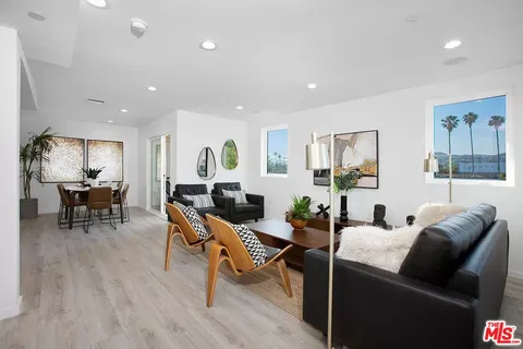 a living room with furniture a wooden floor and a large window