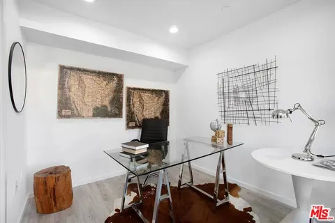 a view of a workspace with furniture and a window