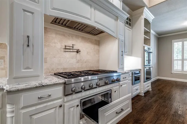 a kitchen with granite countertop a stove and a sink