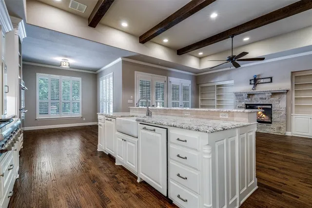 an open kitchen with granite countertop a stove and a wooden floors