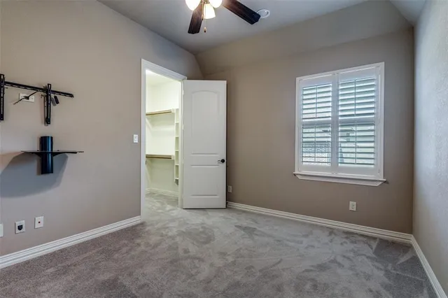 an empty room with fan and windows