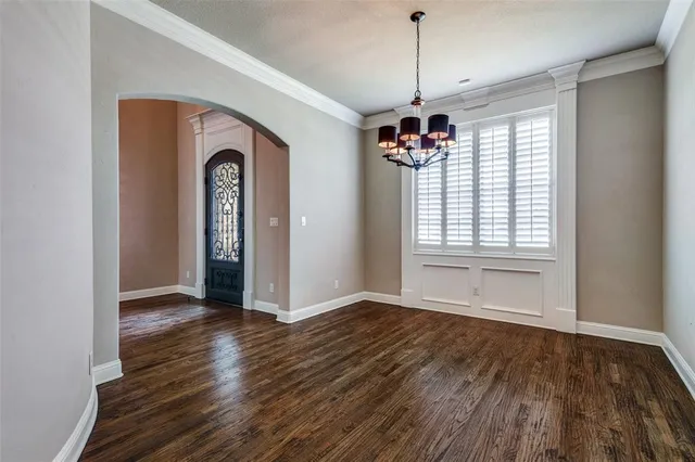 a view of a room with wooden floors ceiling fan and window
