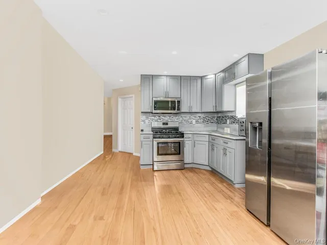 a kitchen with a refrigerator a stove top oven and cabinets