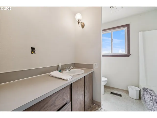 a spacious bedroom with a bed and wooden floor