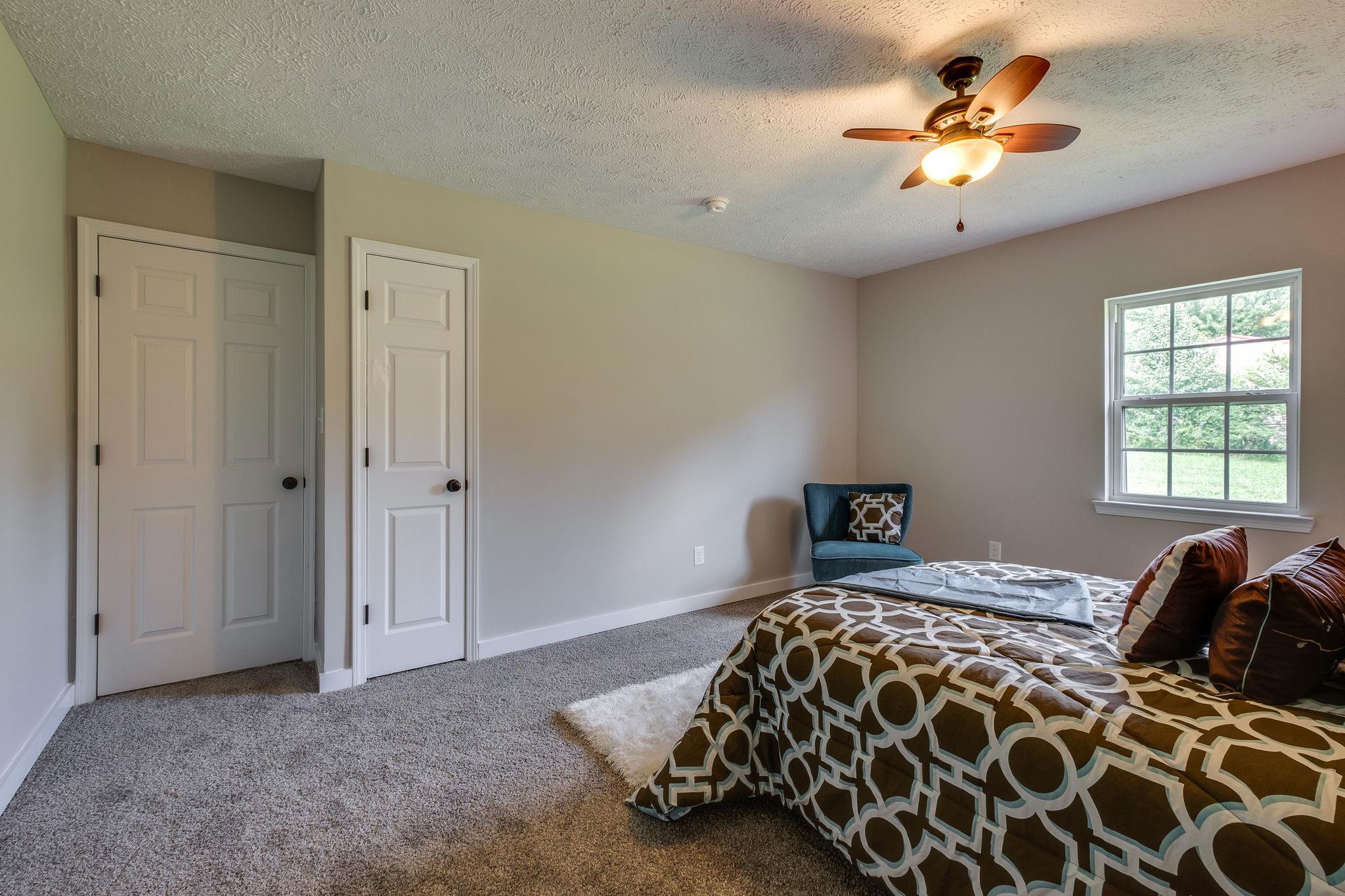 1671 Eno Road Dickson, TN 37055 - Photo 14 of 24 a bedroom with a bed and a chandelier