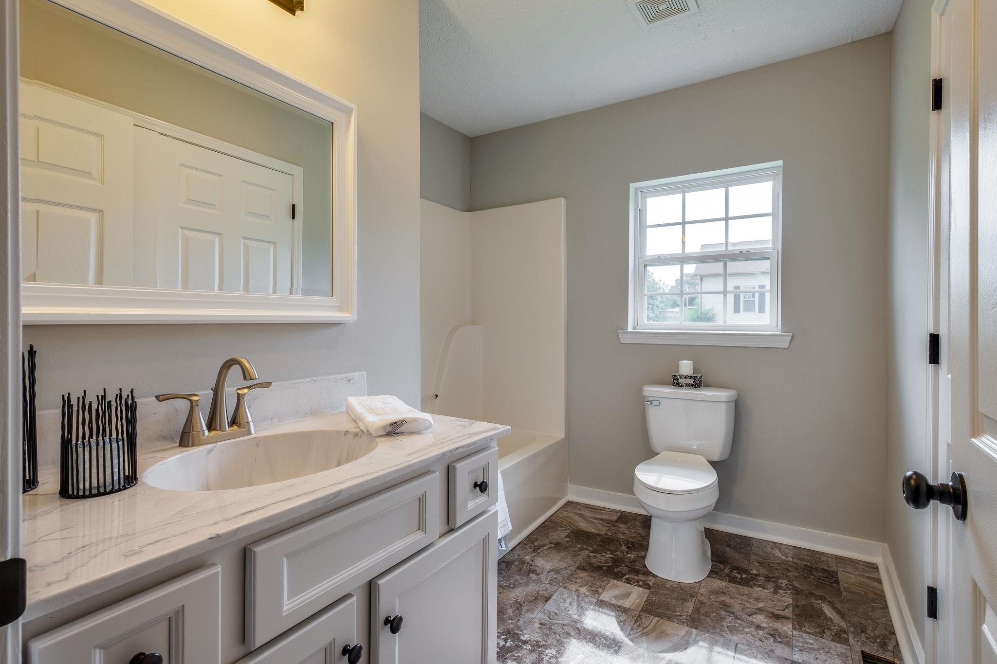 1671 Eno Road Dickson, TN 37055 - Photo 15 of 24 a bathroom with a sink toilet a mirror and vanity