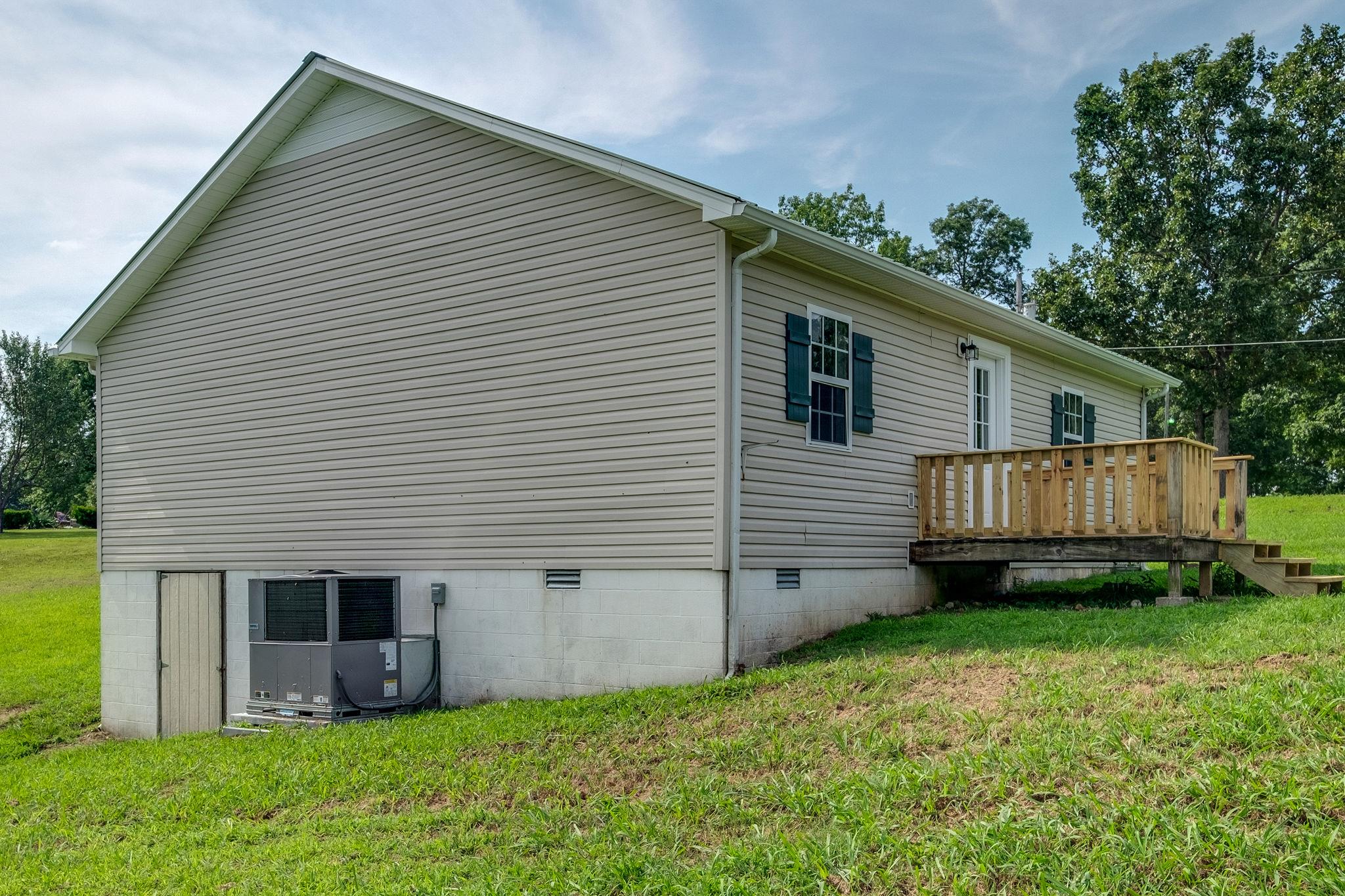 1671 Eno Road Dickson, TN 37055 - Photo 21 of 24 a view of a house with a yard and lawn chairs with wooden fence