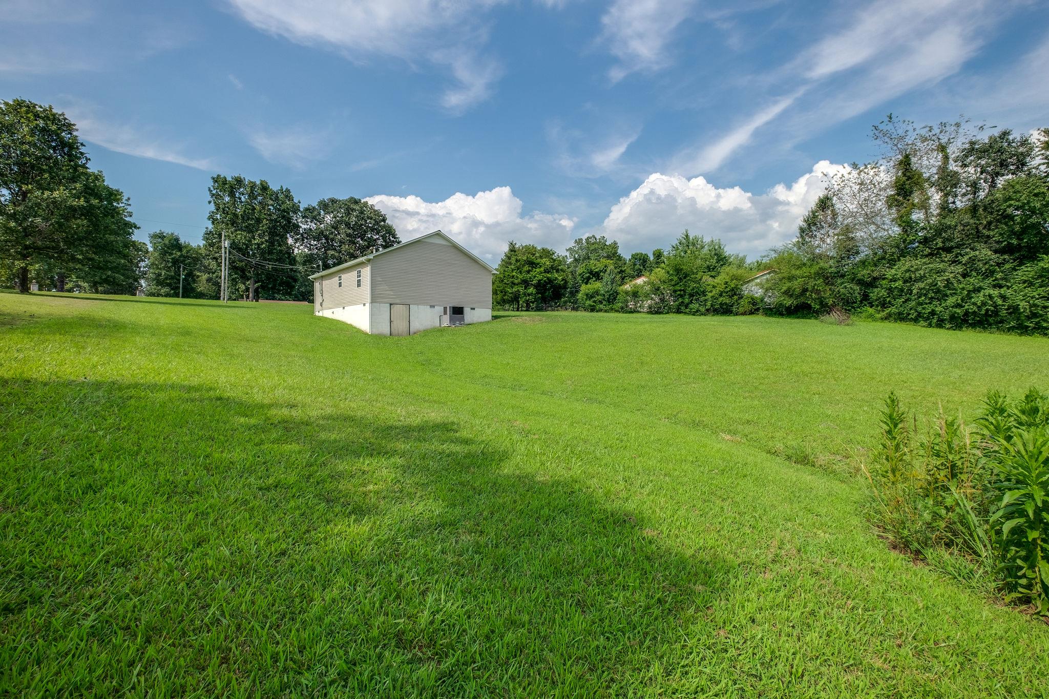 1671 Eno Road Dickson, TN 37055 - Photo 24 of 24 a view of a green field with plants and a large tree