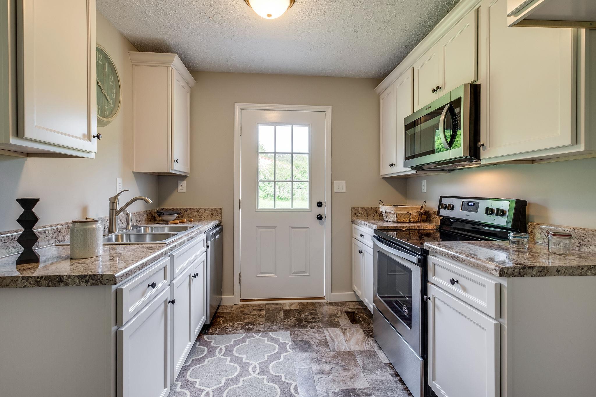1671 Eno Road Dickson, TN 37055 - Photo 6 of 24 a kitchen with stainless steel appliances granite countertop a sink stove and microwave