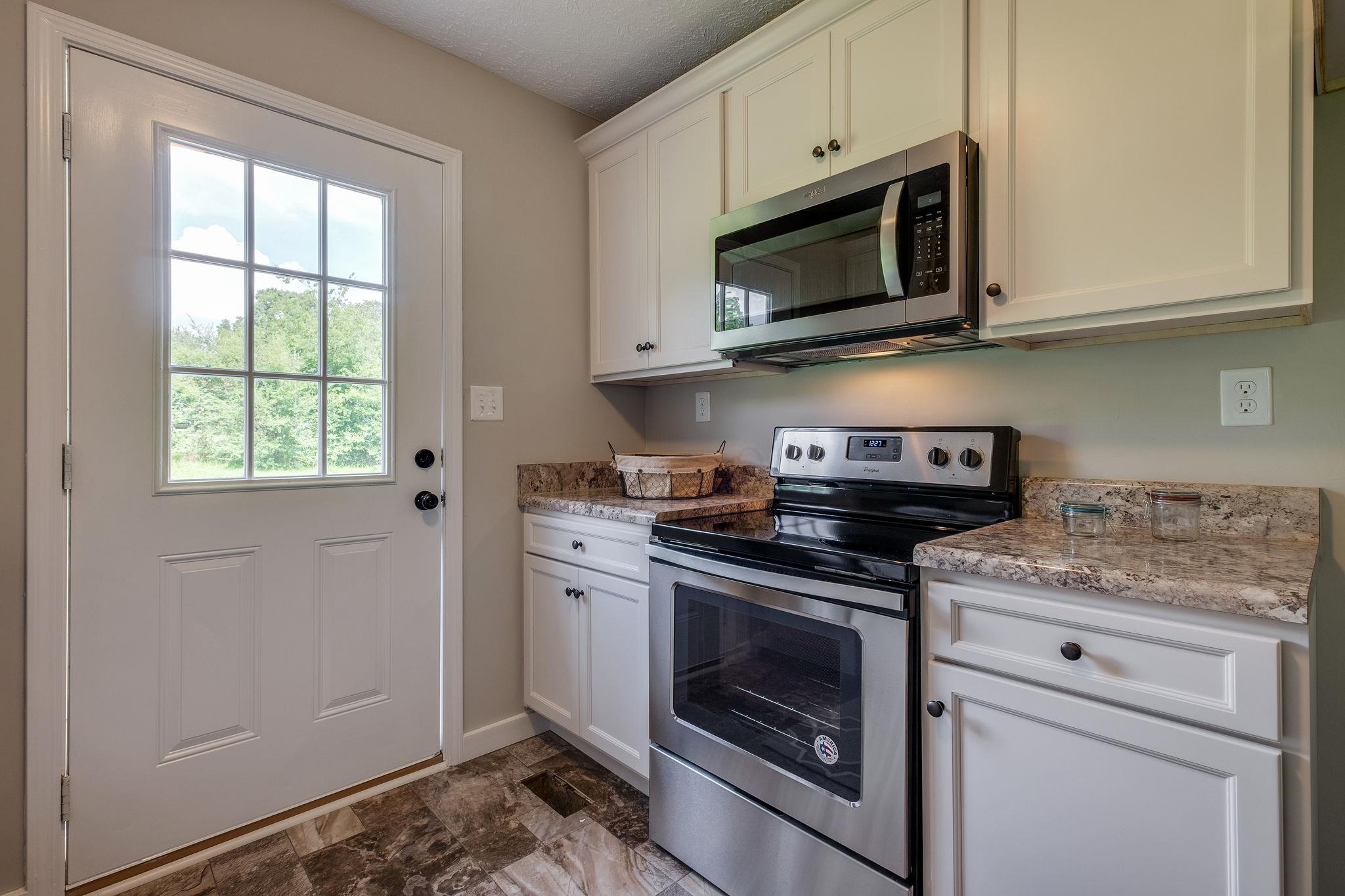 1671 Eno Road Dickson, TN 37055 - Photo 7 of 24 a kitchen with stainless steel appliances granite countertop white cabinets granite counter tops and a window