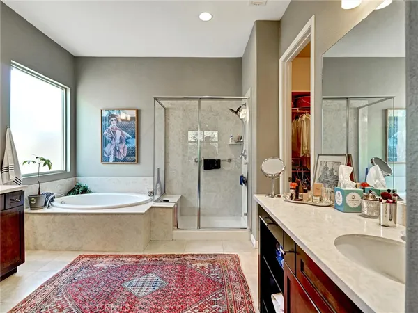 a spacious bathroom with a double vanity sink a mirror and a bathtub