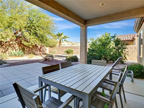 a view of a patio with table and chairs and potted plants