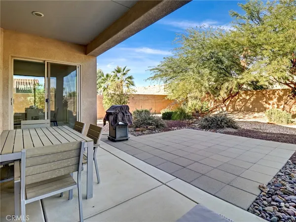 a view of a patio with table and chairs with wooden floor and fence
