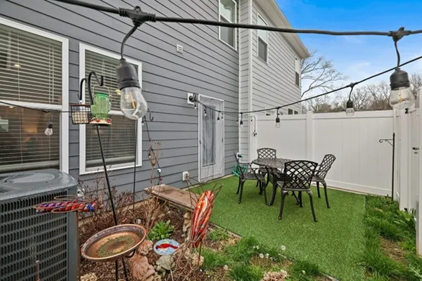 a view of backyard with table and chairs and potted plants