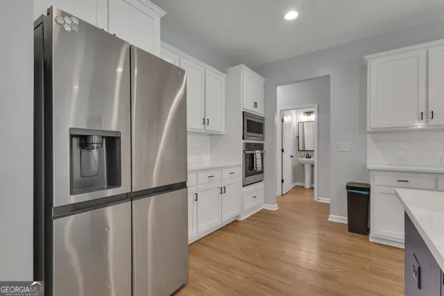 a kitchen with stainless steel appliances a refrigerator and a stove top oven