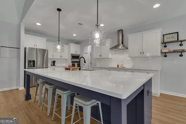 a large kitchen with kitchen island lots of counter space a sink appliances and cabinets
