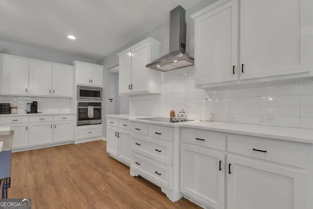 a large kitchen with stainless steel appliances a large counter top a sink a stove and a refrigerator