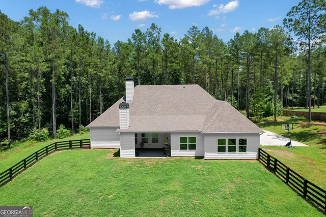 a view of a house with backyard and sitting area