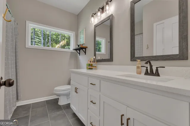 a bathroom with a toilet sink and mirror