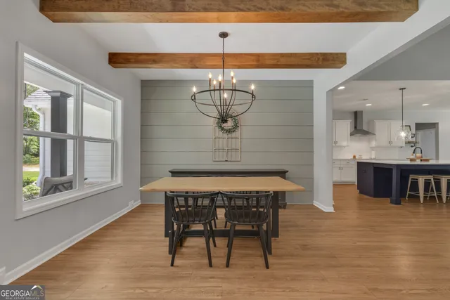 a living room with furniture kitchen view and a wooden floor