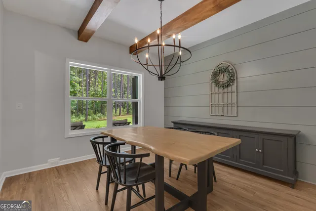 a living room with furniture kitchen view and a wooden floor