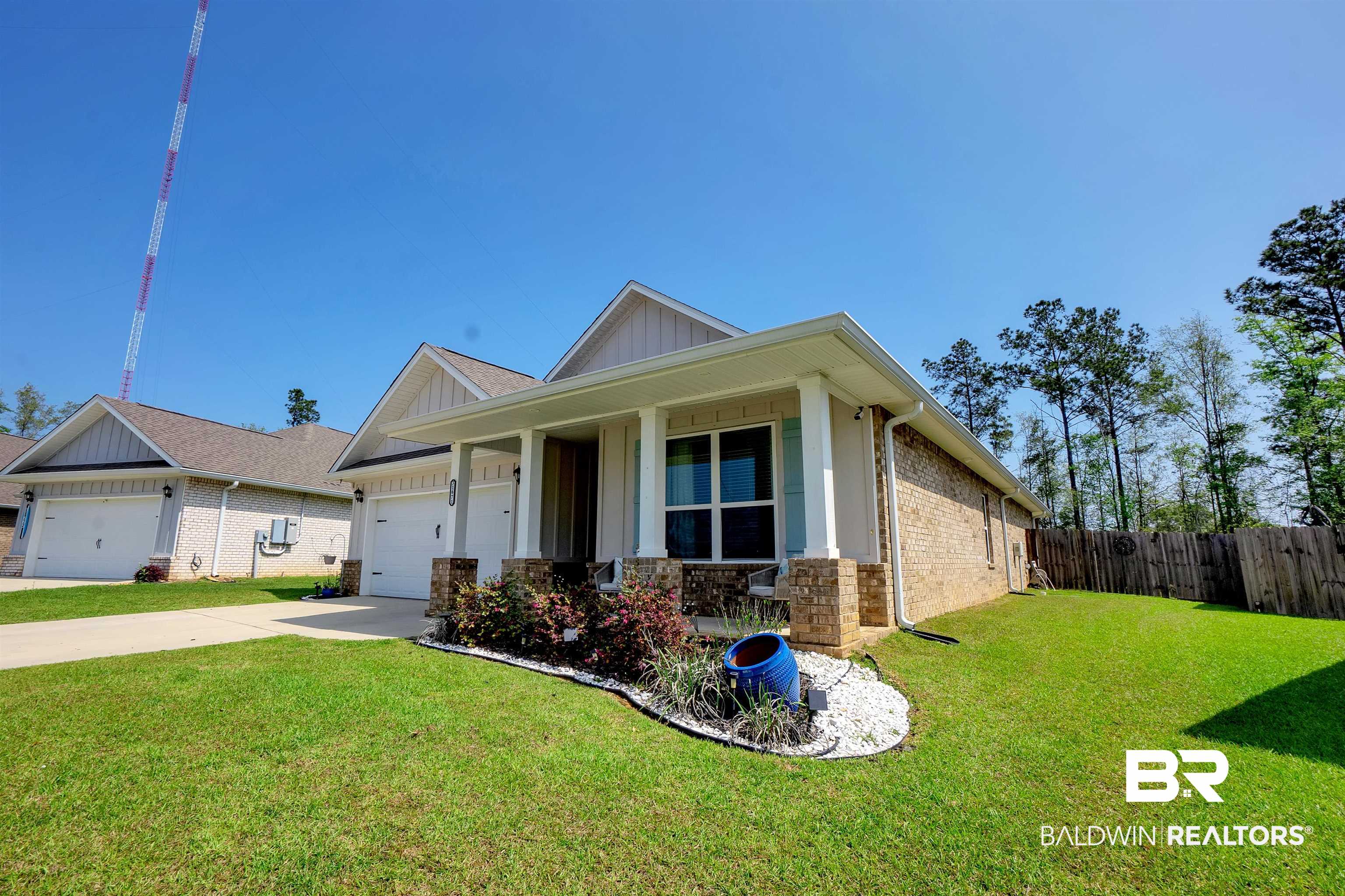 31671 Memphis Loop Daphne, AL 36527 - Photo 3 of 51 View of front of home featuring fence, an attached garage, concrete driveway, a front lawn, and board and batten siding