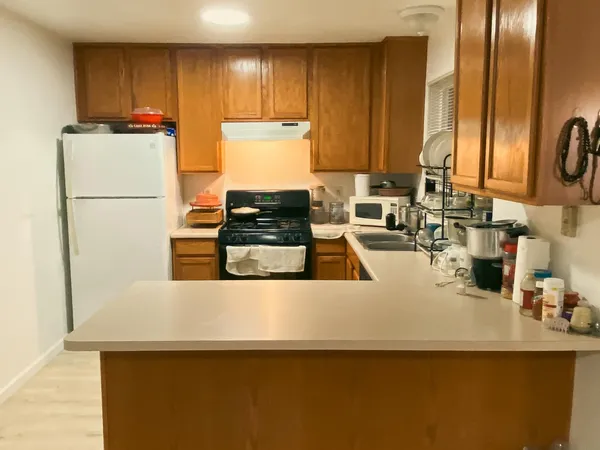a kitchen with kitchen island a counter top space a sink a stove and a refrigerator