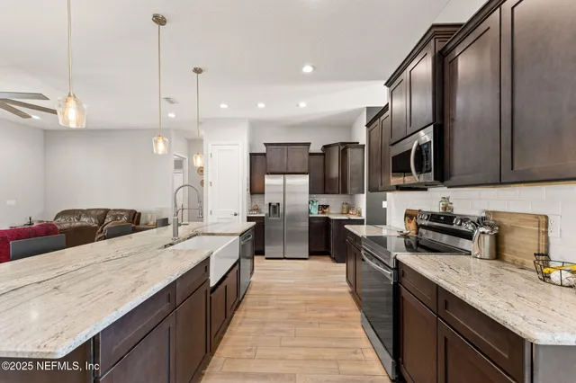 a open kitchen with stainless steel appliances granite countertop a sink stove and refrigerator