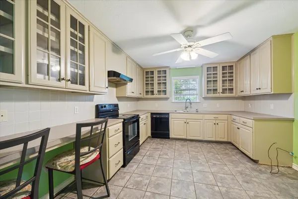 a kitchen with a stove a sink and cabinets