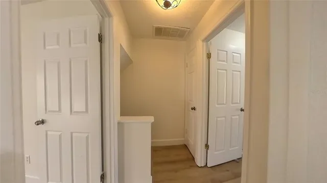 a view of a hallway with wooden floor