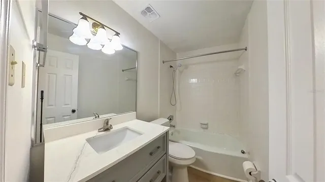 a bathroom with a sink a toilet and a large mirror