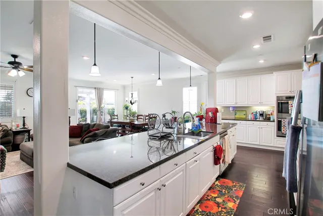 a living room with furniture kitchen view and a large window