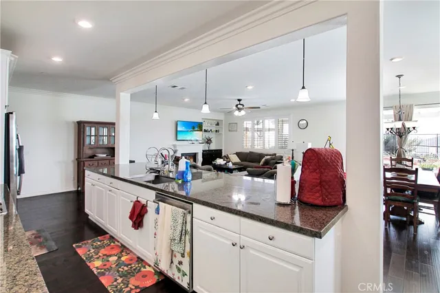 a living room with furniture kitchen view and a chandelier