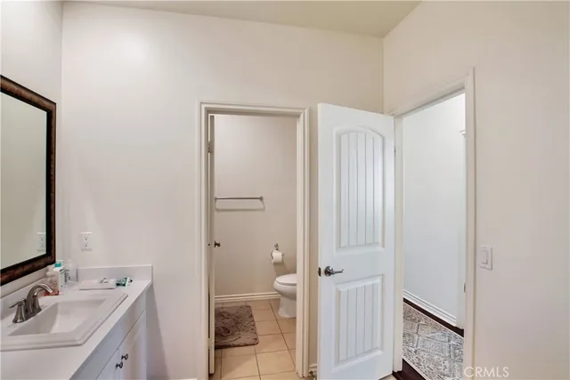 a bedroom with a bed and a mirror on dresser