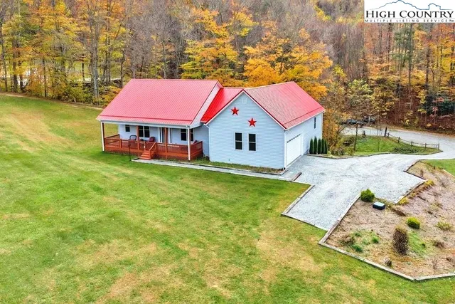 a yellow house with a big yard and large trees