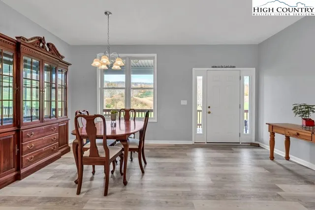 a dining room with furniture a chandelier and wooden floor