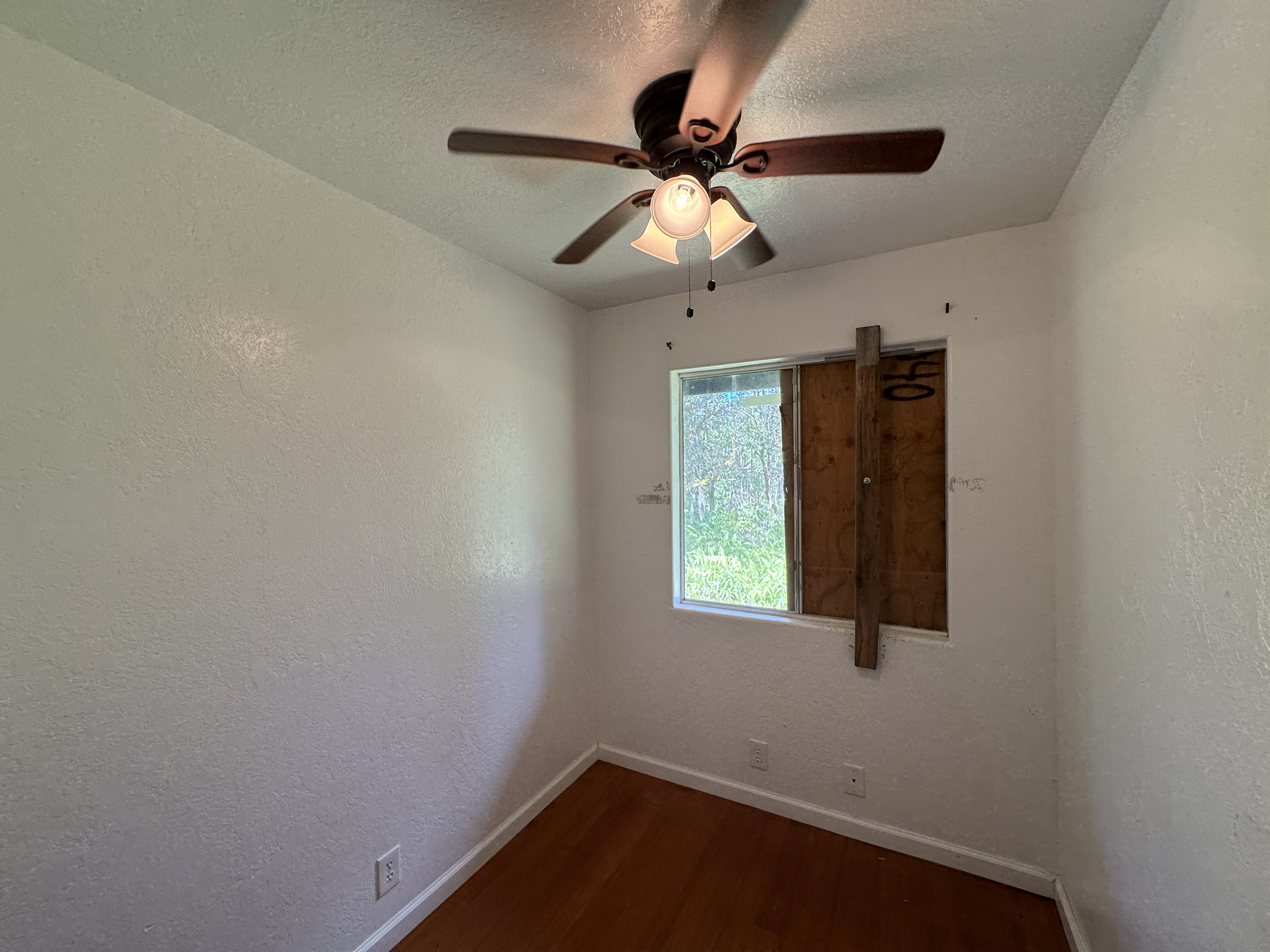 11-3132 Hibiscus Street Mountain View, HI 96771 - Photo 12 of 27 an empty room with a window and a fan