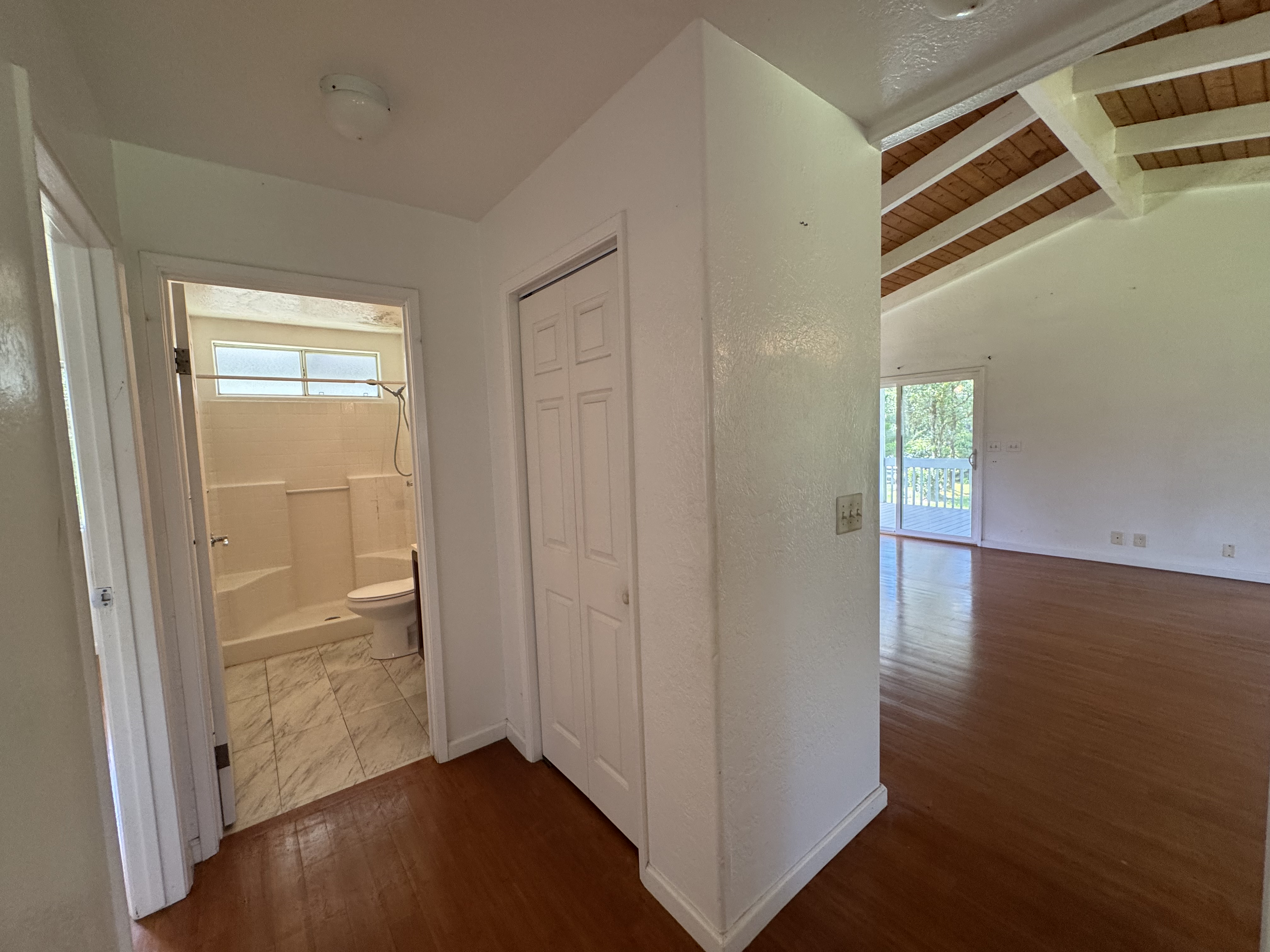 11-3132 Hibiscus Street Mountain View, HI 96771 - Photo 13 of 27 an empty room with wooden floor door and windows