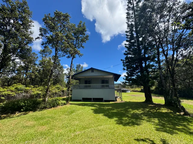 a view of a garden with large trees