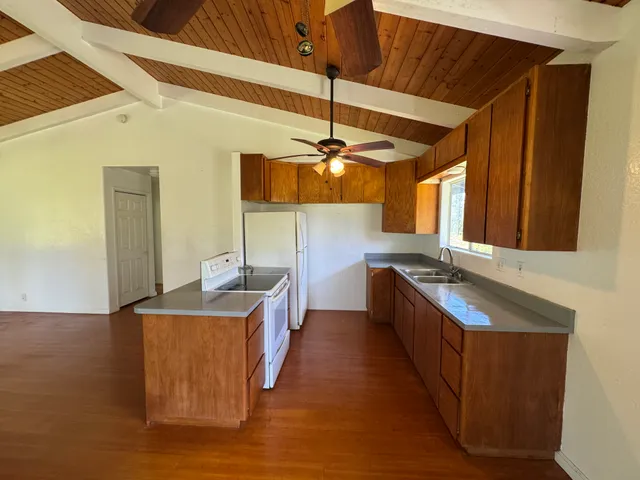 a kitchen with stainless steel appliances granite countertop a sink a stove top oven a counter space and cabinets