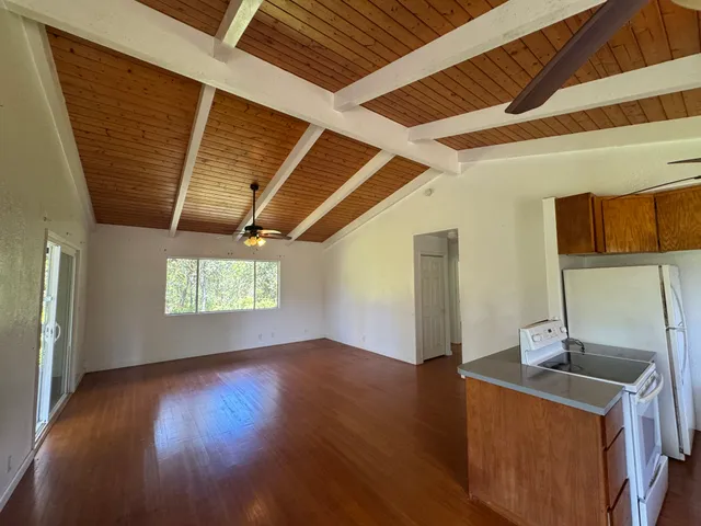 a kitchen with stainless steel appliances granite countertop a sink a stove a refrigerator and wooden floor